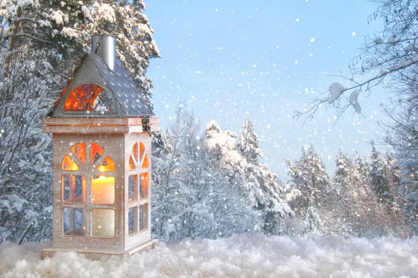 Vieille maison en bois avec bougie sur la neige et fond de paysage hivernal magique flou . — Photo