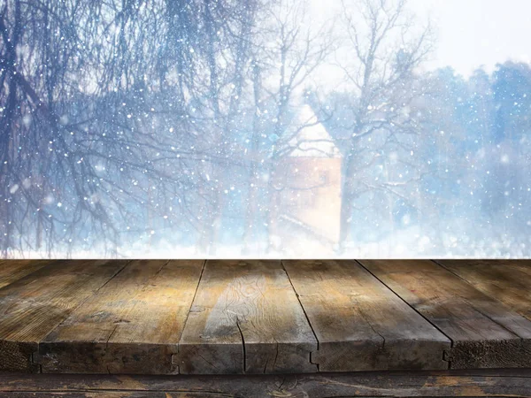 Empty wooden table in front of dreamy and magical winter landscape background. For product display montage.