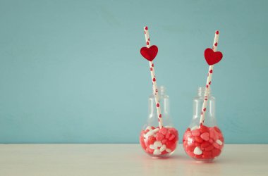 Sevgililer günü romantik arka plan beyaz masa üzerinde kalp şekli tatlı şekerler ile plastik ampul ile