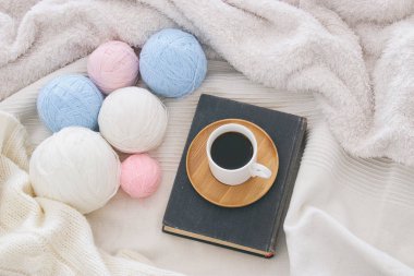 Bir fincan kahve üzerinden rahat ve beyaz battaniye eski kitap. Üstten Görünüm.