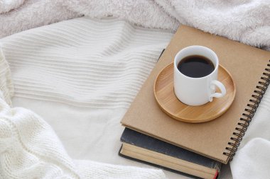 Bir fincan kahve üzerinden rahat ve beyaz battaniye eski kitap. Üstten Görünüm.