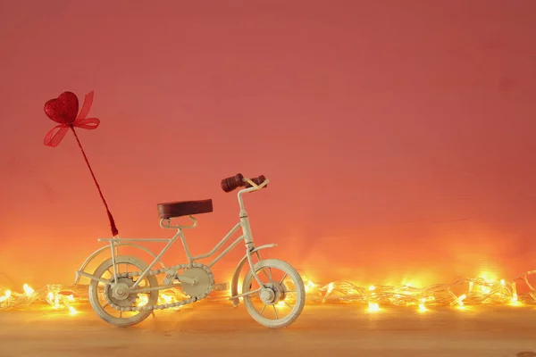 バレンタインの日ロマンチックな背景白ヴィンテージ自転車グッズと木製のテーブルの上に赤いハートのキラキラ. — ストック写真