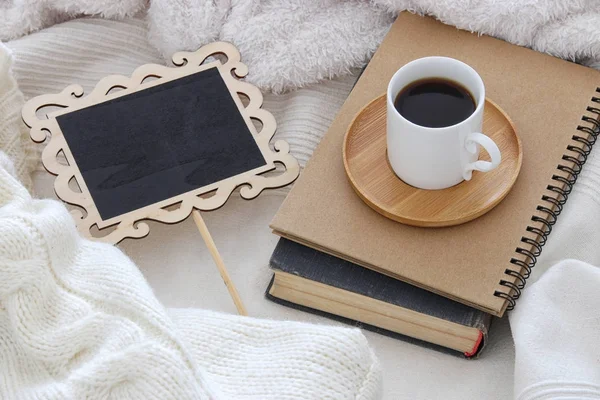Šálek kávy na staré knihy a prázdnou tabuli nad útulné a bílou deku. Pohled shora. — Stock fotografie