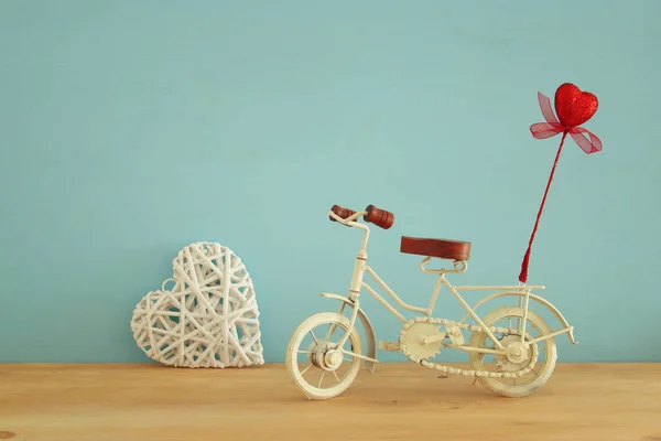 Ημέρα του Αγίου Βαλεντίνου ρομαντική φόντο με λευκό vintage ποδήλατο παιχνίδι και glitter κόκκινη καρδιά σε αυτό πέρα από το ξύλινο τραπέζι. — Φωτογραφία Αρχείου