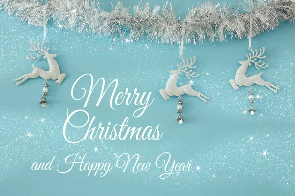 Christmas background with tree festive garland, white deer over light blue background — Stock Photo, Image