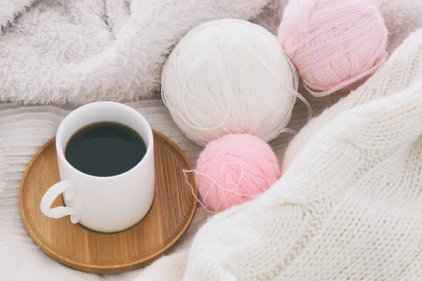 Una taza de café y bolas de lana sobre una manta blanca y acogedora. Vista superior . — Foto de Stock