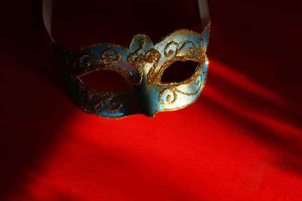 Foto van elegante blauwe en gouden Venetiaanse, mardi gras mask op rode achtergrond. — Stockfoto