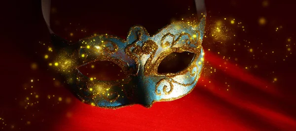 Image of elegant blue and gold venetian, mardi gras mask over red background. Magical glitter ovrlay. — Stock Photo, Image