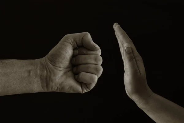 Bilden av manlig näve och kvinnlig hand visar stopp. Koncept för våld mot kvinnor. Svartvitt foto. — Stockfoto