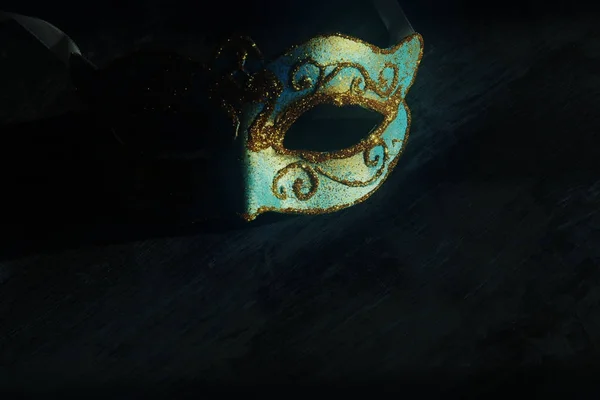 Afbeelding van elegante blauwe en gouden Venetiaanse, mardi gras mask over donkere achtergrond. Vintage gefilterde foto. — Stockfoto