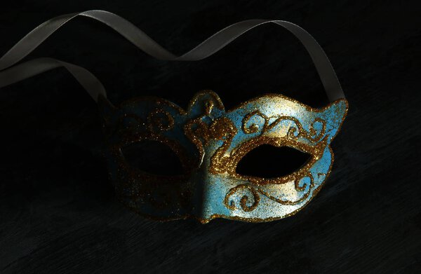 Изображение элегантной сине-золотой венецианской, марди-гра маски на темном фоне
.