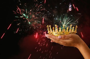 Glitter kaplaması ile siyah arka plan üzerine bir taç Haritayı zafer ya da kazanan ilk yer tutan kadının el.