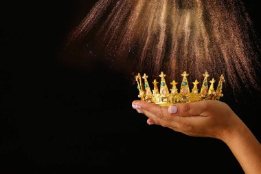 Glitter kaplaması ile siyah arka plan üzerine bir taç Haritayı zafer ya da kazanan ilk yer tutan kadının el.