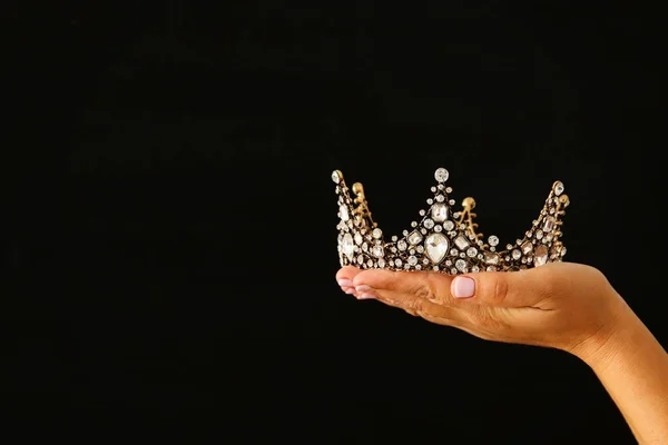 黒背景の上ショーの勝利または勝利最初場所のための王冠を持っている女性の手. — ストック写真