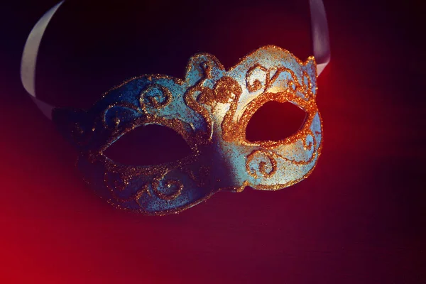 Imagen de elegante máscara veneciana azul y oro sobre fondo rojo . —  Fotos de Stock