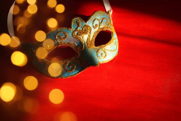 Imagem da elegante máscara veneziana azul e dourada sobre fundo vermelho . — Fotografia de Stock