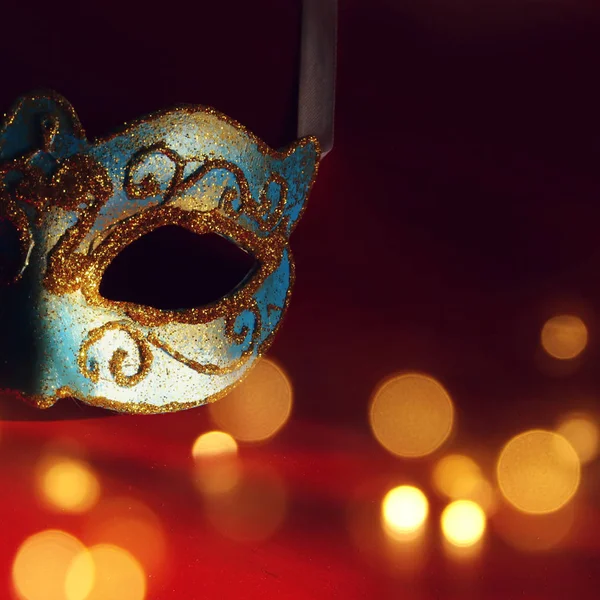 Imagem da elegante máscara veneziana azul e dourada sobre fundo vermelho . — Fotografia de Stock