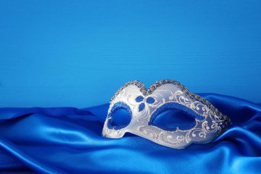 Şık mavi ve altın Venedik Maske mavi ipek kumaş arka plan üzerinde görüntü.
