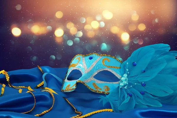 Image of elegant blue and gold venetian mask over blue silk fabric background. — Stock Photo, Image