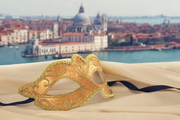 Imagem de máscara veneziana elegante em tecido de seda na frente de fundo embaçado Veneza — Fotografia de Stock