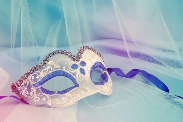 Bild der zarten eleganten venezianischen Maske über blauer Seide und Tüll Hintergrund. — Stockfoto