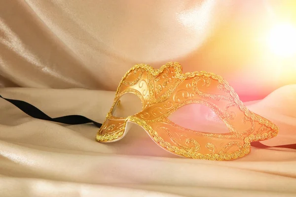 Wizerunek eleganckiej weneckiej masce nad złotym tle jedwabiu. — Zdjęcie stockowe