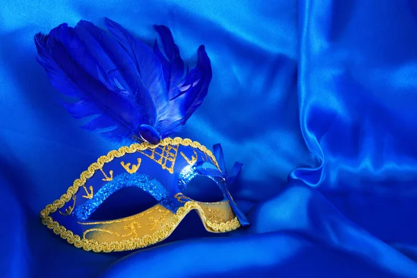 Afbeelding van elegante Venetiaanse masker over blauwe zijde achtergrond. — Stockfoto