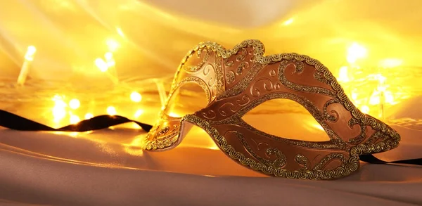 Az elegáns velencei maszk felett arany selyem háttér kép. — Stock Fotó
