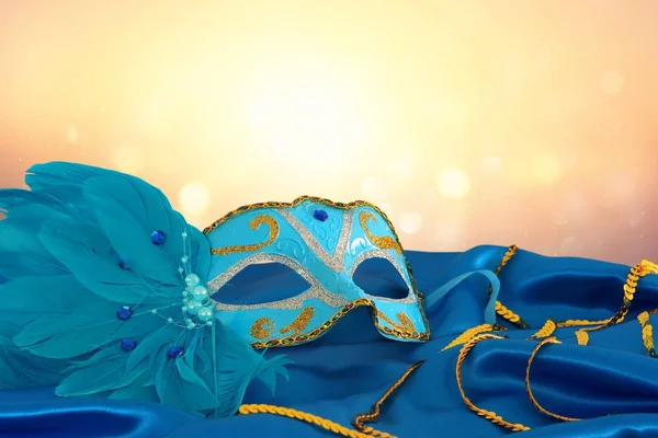 Imagem da elegante máscara veneziana azul e dourada sobre fundo de tecido de seda azul . — Fotografia de Stock