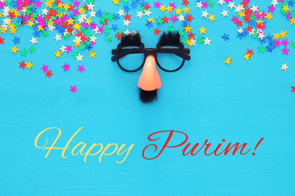 Purim celebration concept (jewish carnival holiday) with funny mustache glasses. Top view