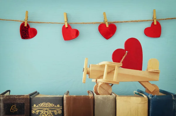 Fond de Saint-Valentin. Avion jouet en bois avec coeur sur de vieux livres . — Photo