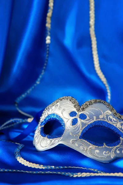 Az elegáns velencei maszk alatt kék selyem háttér kép. — Stock Fotó