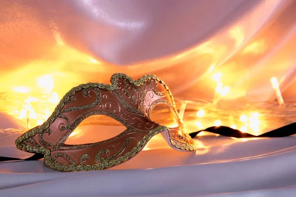 Bilden av elegant venetiansk mask över guld silke bakgrund. — Stockfoto