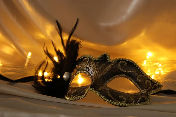 Bild der eleganten venezianischen Maske über goldenem Seidenhintergrund. — Stockfoto