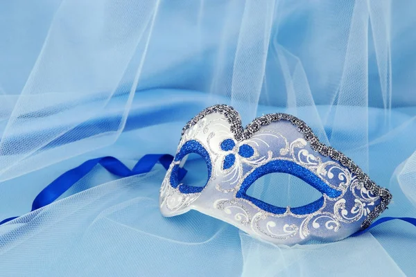 Bilden av delikat elegant venetiansk mask över Blå siden och tyll tyg bakgrund. — Stockfoto