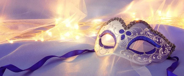 Bild einer zarten, eleganten venezianischen Maske über blauer Seide und Tüll — Stockfoto