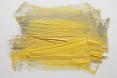 Beyaz arka plan üzerinde sarı suluboya fırça darbesi.