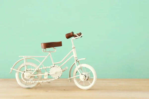 Vintage metal blanco bicicleta juguete sobre mesa de madera . — Foto de Stock