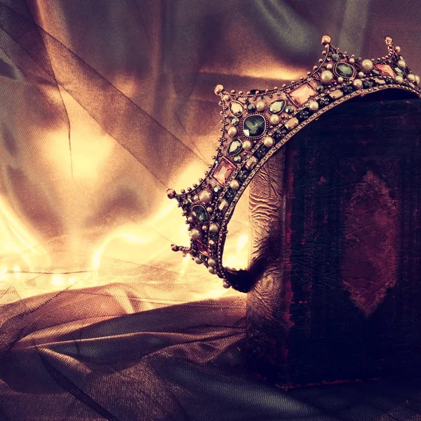 Imagem chave baixa de bela rainha / rei coroa no livro antigo. período medieval fantasia . — Fotografia de Stock