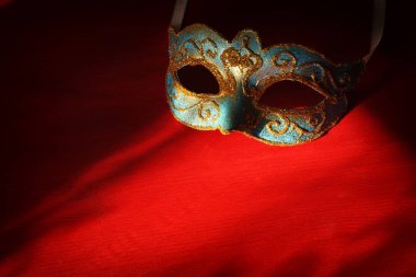 Şık mavi ve altın Venedik Maske üzerinde kırmızı bir arka plan görüntüsü.