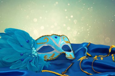 Şık mavi ve altın Venedik Maske mavi ipek kumaş arka plan üzerinde görüntü.