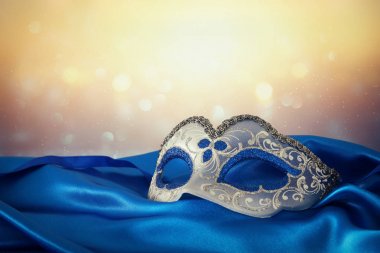Şık mavi ve altın Venedik Maske mavi ipek kumaş arka plan üzerinde görüntü.