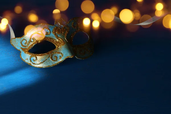 Foto van elegante blauwe en gouden Venetiaanse, mardi gras mask over blauwe achtergrond. — Stockfoto