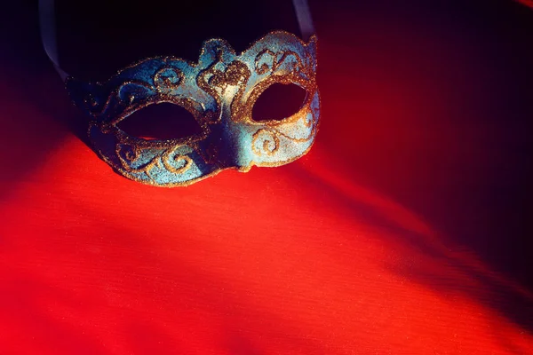 Bild von eleganten blauen und goldenen venezianischen Maske auf rotem Hintergrund. — Stockfoto