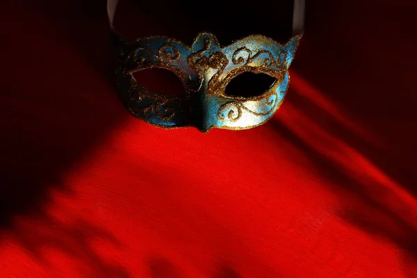 Image élégante vénitienne bleue et dorée, masque mardi gras sur fond rouge . — Photo
