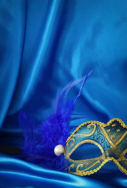 Az elegáns velencei maszk alatt kék selyem háttér kép. — Stock Fotó