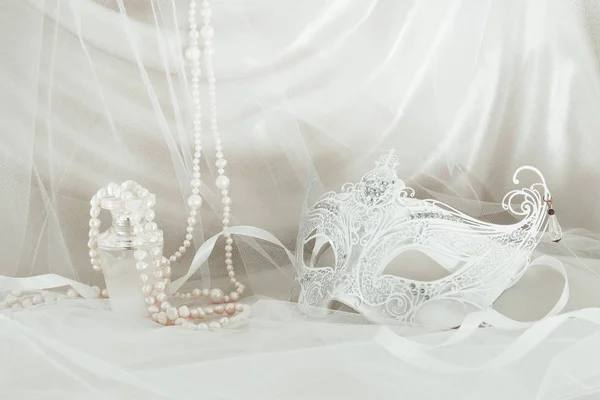 Image of delicate and elegant white venetian mask in front of tulle background. — Stock Photo, Image