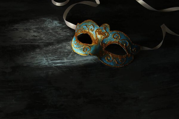 Изображение элегантной сине-золотой венецианской маски Марди Гра на черном фоне
.