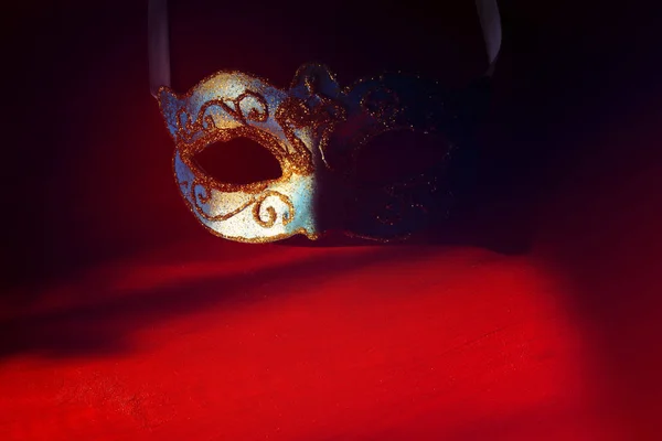 Image d'un élégant masque vénitien bleu et or sur fond rouge . — Photo