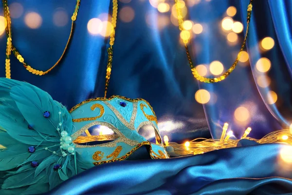 Imagem de elegante máscara veneziana sobre fundo de seda azul . — Fotografia de Stock